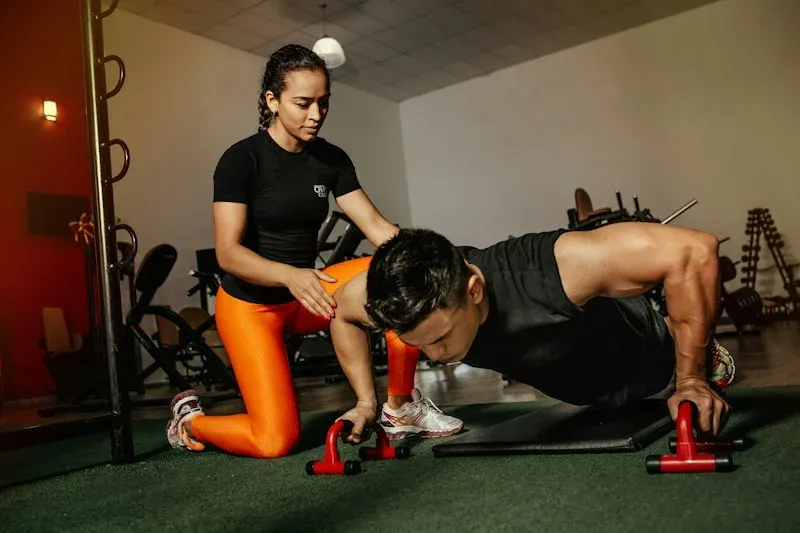 A coach supporting a gym workout